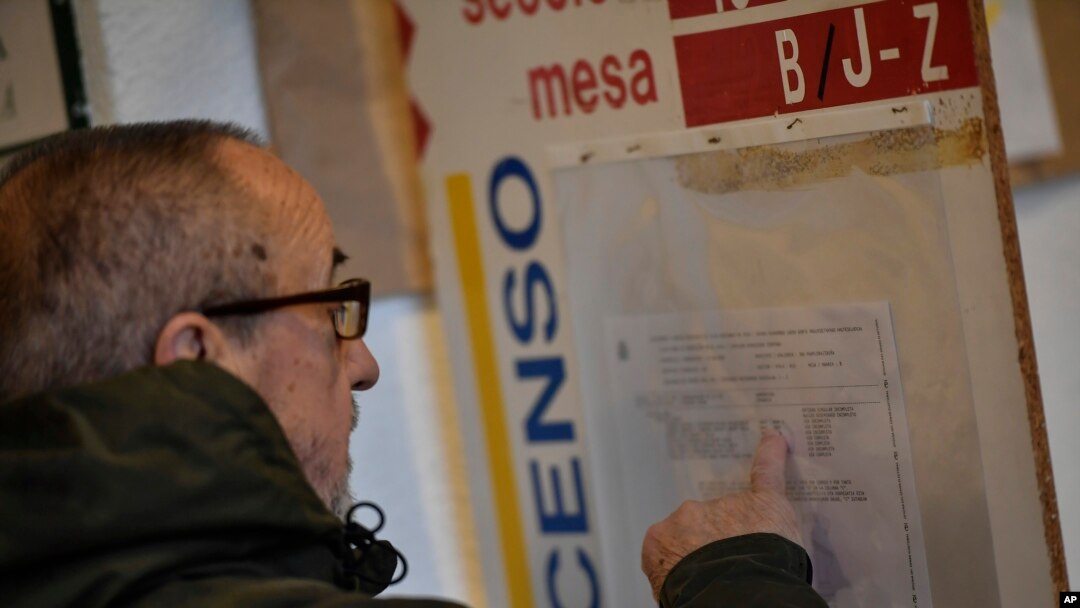 A man checks a panel at a polling station before casting his vote for the general election in Pamplona, northern Spain, Nov. 10, 2019. 