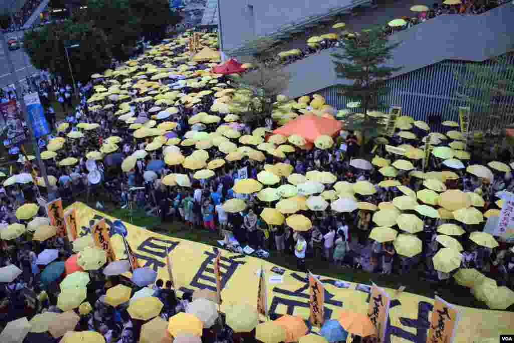 接近1,000名集會人士高舉黃傘默站，紀念香港警察去年向示威者施放催淚彈。(美國之音特約記者湯惠芸照)