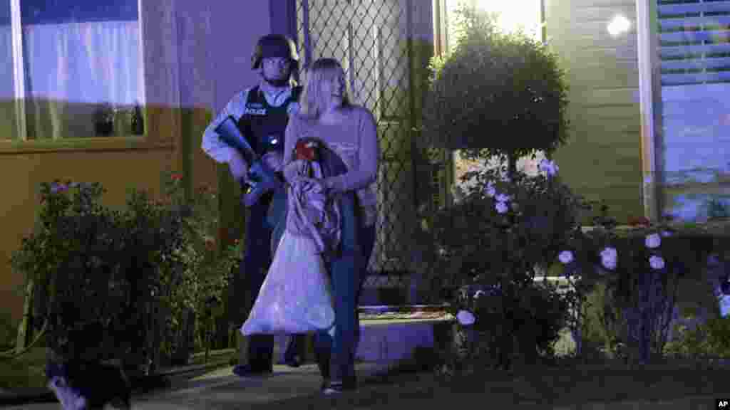 Un policier accompagne une femme chez elle après la fusillade, à Redlands, en Californie, 2 décembre 2015.,&nbsp;