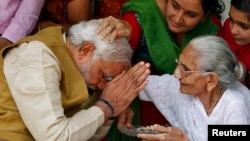 Narendra Modi (kiri), calon perdana menteri dari Partai Bharatiya Janata memohon restu dari ibunya Heeraben di rumahnya di Gandhinagar, Gujarat (16/5/2014). Modi akan menjadi Perdana Menteri India yang baru. 