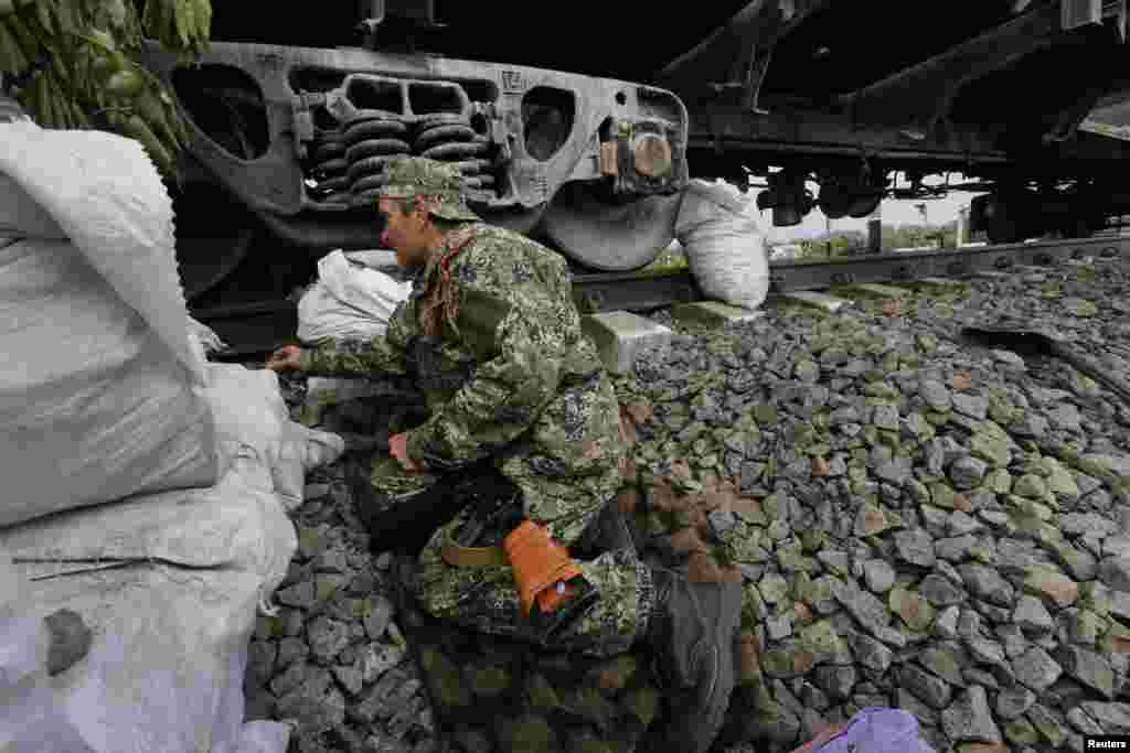 Seorang tentara pemberontak pro-Rusia mengambil posisi di kota Slaviansk, Ukraina timur (12/5). (Reuters/Yannis Behrakis)