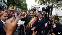 FILE - Venezuela's President Nicolas Maduro, center, greets supporters as he arrives at the National Constituent Assembly's building during the celebration rally of the 20th anniversary of the Venezuelan Constitution in Caracas, Venezuela, Dec. 15, 2019.