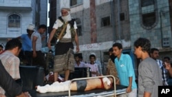 Tribal fighters, against Shiite rebels known as Houthis, carry a boy who was killed during fighting between the two groups, in Taiz, Yemen, Aug. 20, 2015.