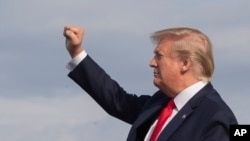President Donald Trump gestures as he disembarks Air Force One upon arrival at Wheeling, West Virginia, July 24, 2019. 