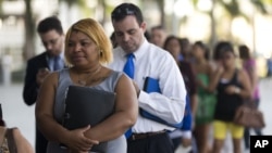 Fila de personas buscando trabajo en una feria de empleos en Miami, Florida.