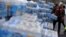 FILE - Volunteers distribute bottled water to residents in Flint, Michigan, March 5, 2016. 