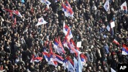 People waving Serbian flags crowd a square in front of the General Assembly building during an anti-government rally in Belgrade, February 5, 2011