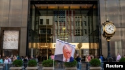 Zastava koja prikazuje bivšeg američkog predsjednika Trumpa ispred Trump Towera u New Yorku.