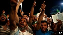 Demonstranti uzvikuju parole protiv aktuelnog ministra odbrane generala Abdel-fataha el-Sisija u blizini Raba al-Adavija džamije