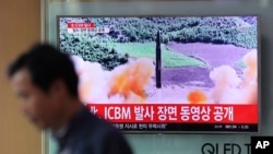 A man walks past a TV screen showing a local news program about North Korea's reported firing of an ICBM, at Seoul Train Station in Seoul, South Korea, July 5, 2017.