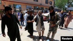 Men carry an injured person to a hospital after a blast during a funeral ceremony in Jalalabad, Afghanistan, May 12, 2020.