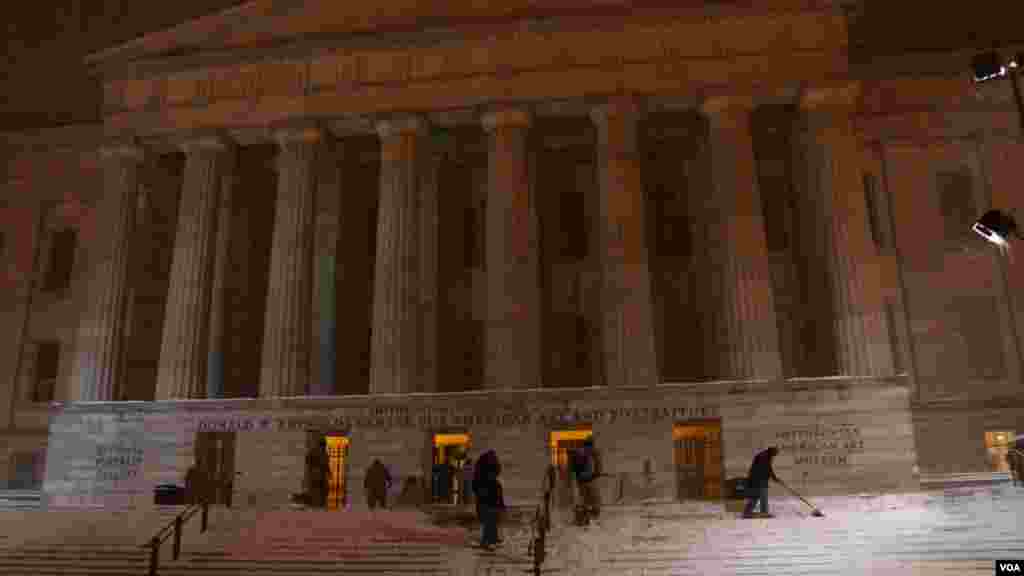 Workers at the Smithsonian Institution's National Portrait Gallery worked to keep the building's steps clear of snow (P. Datcher/VOA)