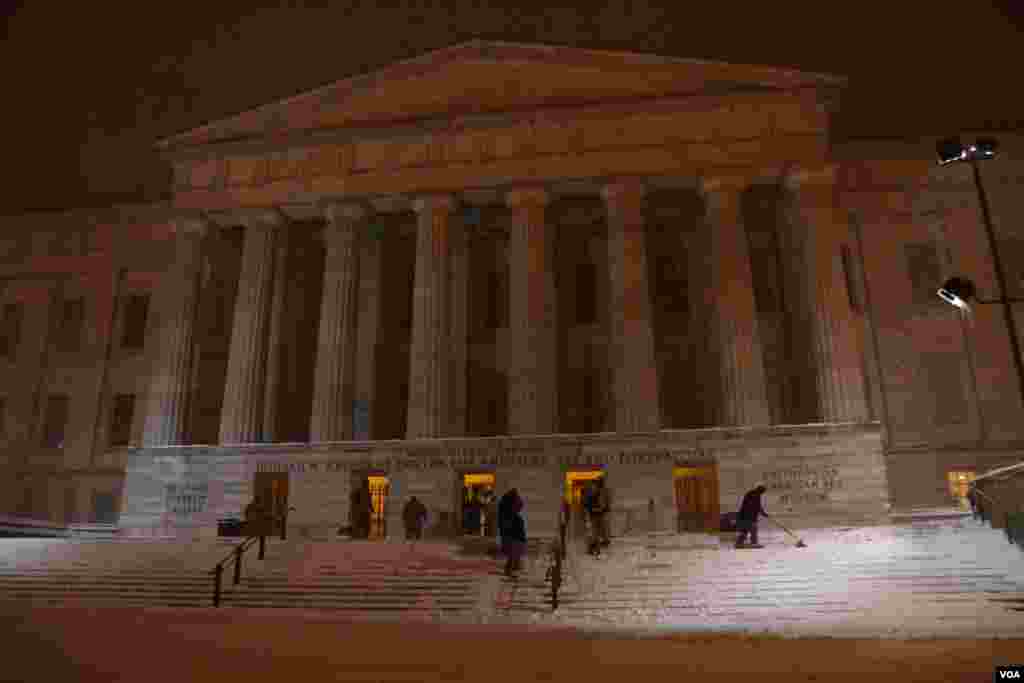 Workers at the Smithsonian Institution's National Portrait Gallery worked to keep the building's steps clear of snow (P. Datcher/VOA)