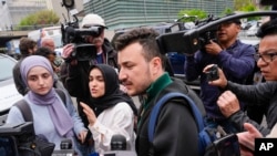 FILE - Members of the Columbia University Apartheid Divest group, including Mahmoud Khalil, center, are surrounded by members of the media outside the Columbia University campus, April 30, 2024, in New York.