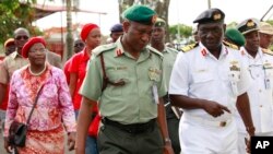 Brig. Gen. Chris Olukolade, Nigeria's top military spokesman, center, walks with representatives of kidnapped schoolgirls of Chibok secondary school, for a meeting at the defense headquarters in Abuja, Nigeria, May 6, 2014. 
