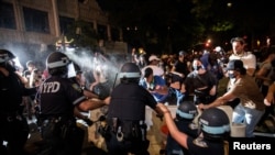 A police officer sprays protesters during a march against the death in Minneapolis police custody of George Floyd, in the Brooklyn borough of New York City, May 30, 2020. 