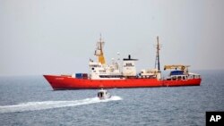 In this photo taken on Friday, June 1, 2018 the rescue vessel Aquarius ship approaches the Pozzallo harbor, Southern Italy. Spain stepped up June 11, 2018 and offered to take in a rescue ship carrying more than 600 migrants after Italy and Malta refused.