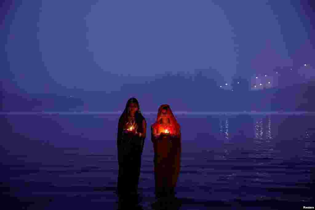 Hindu devotees worship the Sun god as they stand in the polluted waters of the river Yamuna during the Hindu religious festival of Chhath Puja on a smoggy morning in New Delhi, India.