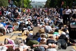 Demonstrators lie on the pavement facing the White House during a rally north of Lafayette Square to protest police brutality and racism, in Washington, June 7, 2020.