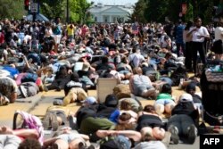 Demonstrators lie on the pavement facing the White House during a rally north of Lafayette Square to protest police brutality and racism, in Washington, June 7, 2020.