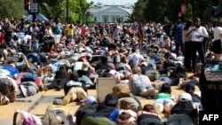 Demonstrators lie on the pavement facing the White House during a rally north of Lafayette Square to protest police brutality and racism, in Washington, June 7, 2020. 