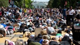 Demonstrators lie on the pavement facing the White House during a rally north of Lafayette Square to protest police brutality and racism, in Washington, June 7, 2020.