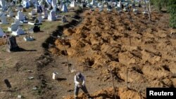 A worker prepares graves for inmates who died during a prison riot, at the cemetery of Taruma in Manaus, Brazil, Jan. 4, 2017. 
