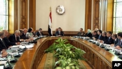 In this image released by the Egyptian Presidency, President Mohammed Morsi, center, meets with his Cabinet including new ministers at the presidential palace in Cairo, January 6, 2013.