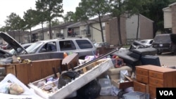 When the rains stopped in the Houston area for several hours Tuesday, residents pulled water-damaged carpets, furniture and other belongings out of their apartment buildings, leaving piles of debris outside their doors. (G. Flakus/VOA)