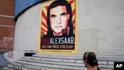 Una mujer camina cerca de un cartel pidiendo la libertad del empresario colombiano y enviado especial venezolano Alex Saab, en Caracas, Venezuela, el16 de octubre de 2021. 