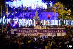 FILE - Women hold a giant banner reading 'Abolition of prostitution' during a demonstration to mark the International Day for the Elimination of Violence against Women in Madrid on Nov. 25, 2019.