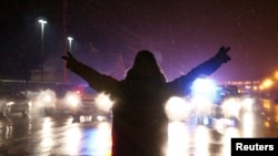 FILE - A protester walks in the street with his hands up after the grand jury verdict in the Michael Brown shooting in Ferguson, Missouri, Nov. 26, 2014.