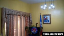 A picture of the late Haitian President Jovenel Moise hangs on a wall before a news conference, July 13, 2021.