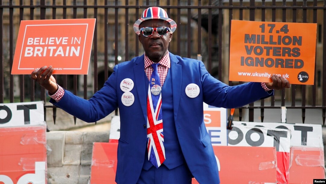 A pro-Brexit supporter holds placards outside the Houses of Parliament, following the Brexit votes the previous evening, in London, March 28, 2019.