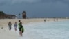 Tourists stand on a beach as Tropical Storm Helene approaches the Yucatan Peninsula, in Cancun, Mexico Sept. 24, 2024. 