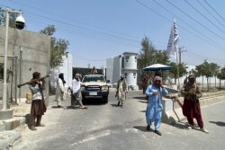 Taliban fighters stand guard at an entrance gate outside the Interior Ministry in Kabul, August 17, 2021.