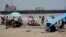 Grupos de visitantes en las playas de Port Aransas, Texas, antes de la llegada del huracán Beryl, el 6 de julio de 2024. La ciudad emitió una orden de evacuación para todos los visitantes a partir del domingo 7 de julio al mediodía.
