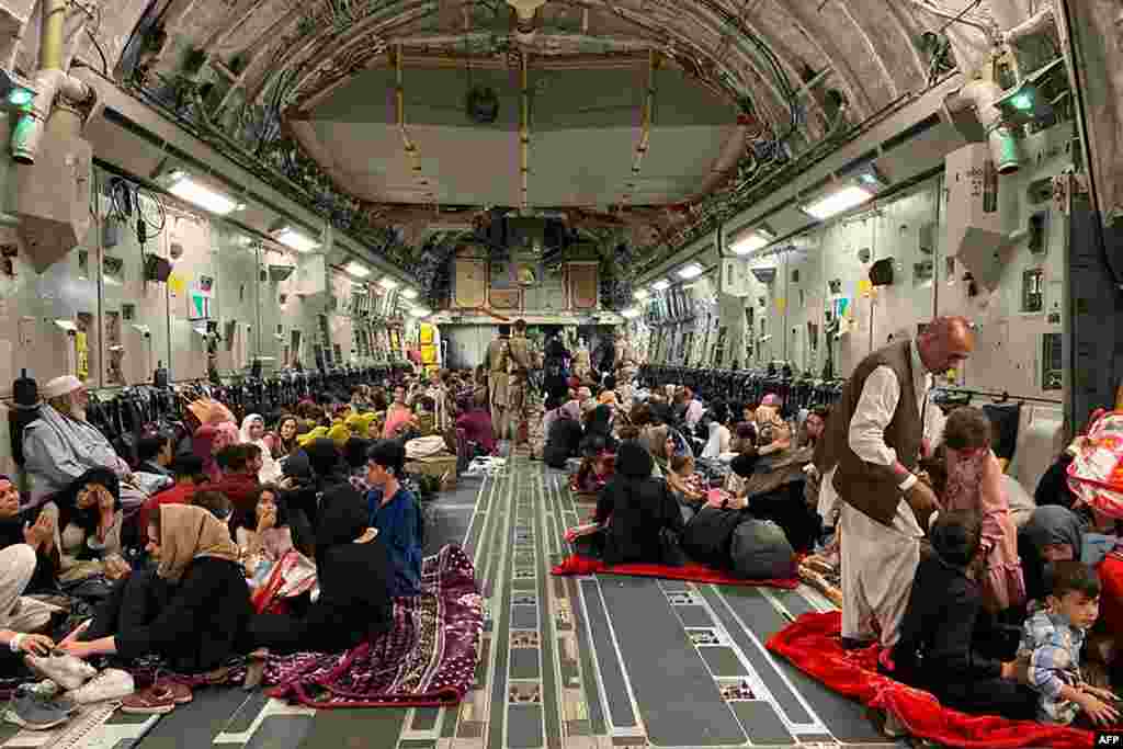 아프가니스탄 카불 비행장에서 아프가니스탄을 떠나려는 주민들이 미 공군 수송기에 타고 있다.