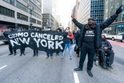 FILE - Activists with VOCAL-NY block traffic outside New York Gov. Andrew Cuomo's office, demanding his resignation, in New York, March 10, 2021.