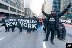 FILE - Activists with VOCAL-NY block traffic outside New York Gov. Andrew Cuomo's office, demanding his resignation, in New York, March 10, 2021.
