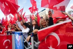 Pendukung ketua partai CHP Turki dan kandidat presiden Aliansi Bangsa Kemal Kilicdaroglu mengibarkan bendera Turki saat kampanye pemilu di Ankara, Turki, Jumat, 12 Mei 2023. (Foto: AP)