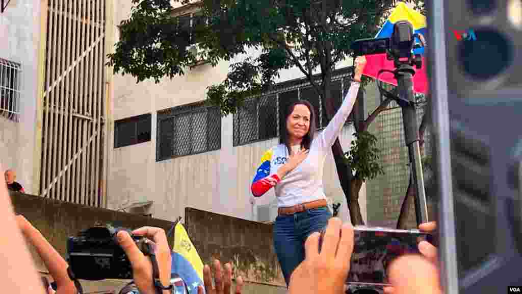 María Corina Machado levanta la bandera de Venezuela durante la manifestación opositora, a un día de la investidura presidencial en Venezuela.