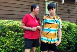 Molly Ball talks to her son Henry about plans to send him back to in-person classes this fall, as they stand outside their house in Woodstock, Ga., July 23, 2020.