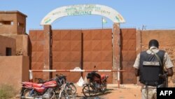 Un gendarme nigérien se tient près des motocyclettes calcinées utilisées par les assaillants, devant la prison de Koutoukale, près de Niamey, suite à une attaque le 17 octobre 2016.