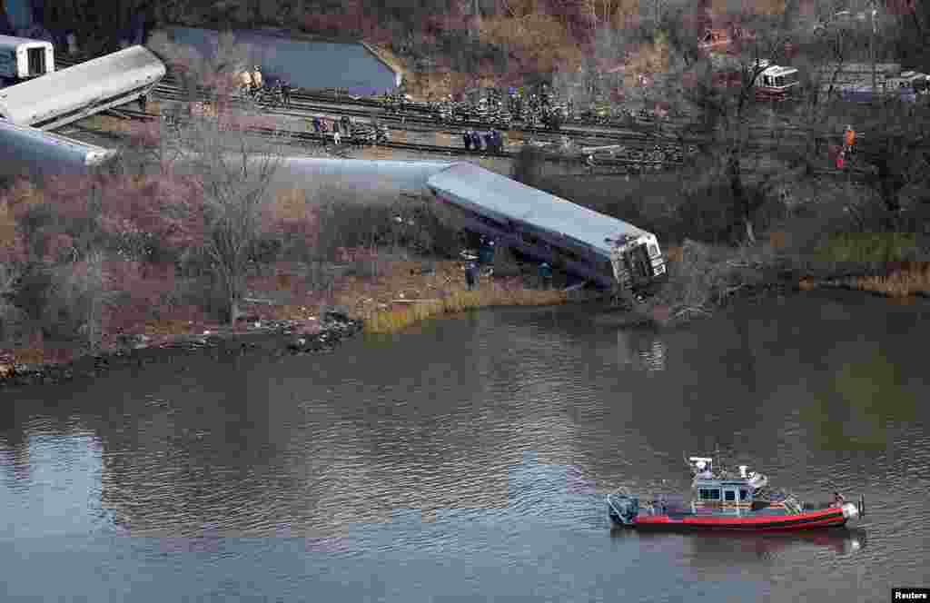 Emergency workers gather at the site of a Metro-North train derailment in the Bronx borough of New York. At least four people were killed and 63 injured, including 11 critically, when the suburban train derailed, with at least five cars from the Metro-North train sliding off the tracks, officials said.