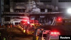 Ambulances are parked outside a damaged warehouse which is currently under construction, after it caught fire, in Icheon, South Korea, April 29, 2020.