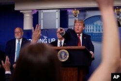 FILE - President Donald Trump points to a reporter to ask a question as he speaks about the coronavirus in the James Brady Press Briefing Room of the White House, in Washington, April 16, 2020.