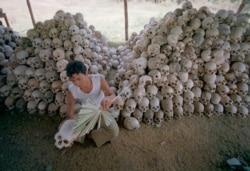 In this undated file photo, a man cleans a skull near a mass grave at the Chaung Ek torture camp that was run by Cambodia's Khmer Rouge.