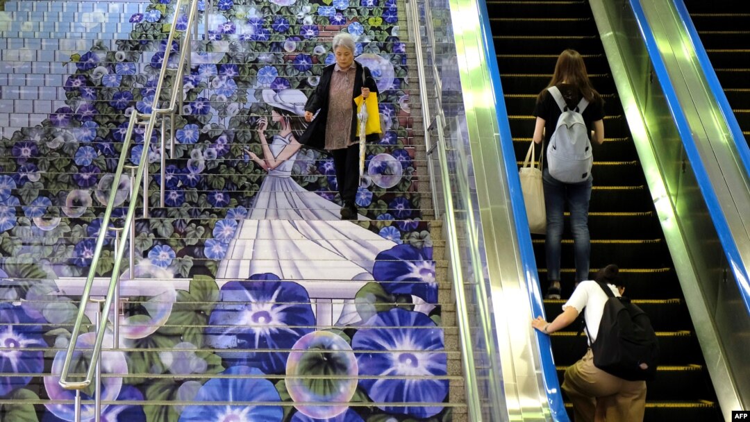 Seorang komuter berjalan menuruni tangga di pintu masuk Stasiun JR Kumagaya di Kumagaya, Prefektur Saitama pada 15 Juli 2019. (Foto: AFP / Kazuhiro Nogi)