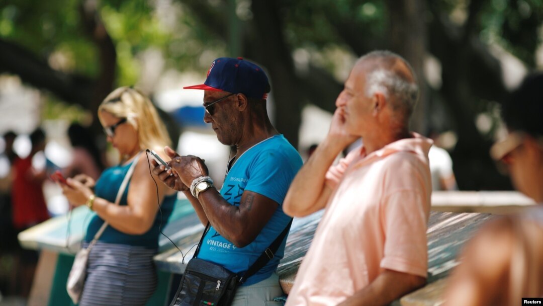 Cubanos comprueban la conexión a internet desde teléfonos móviles en La Habana, Cuba, el 10 de agosto de 2018.